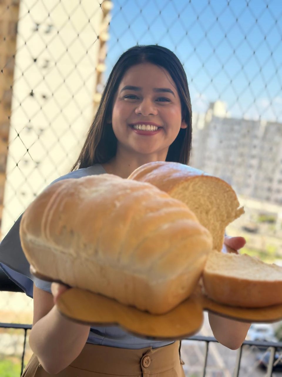 Mari na varanda segurando a fornada do dia